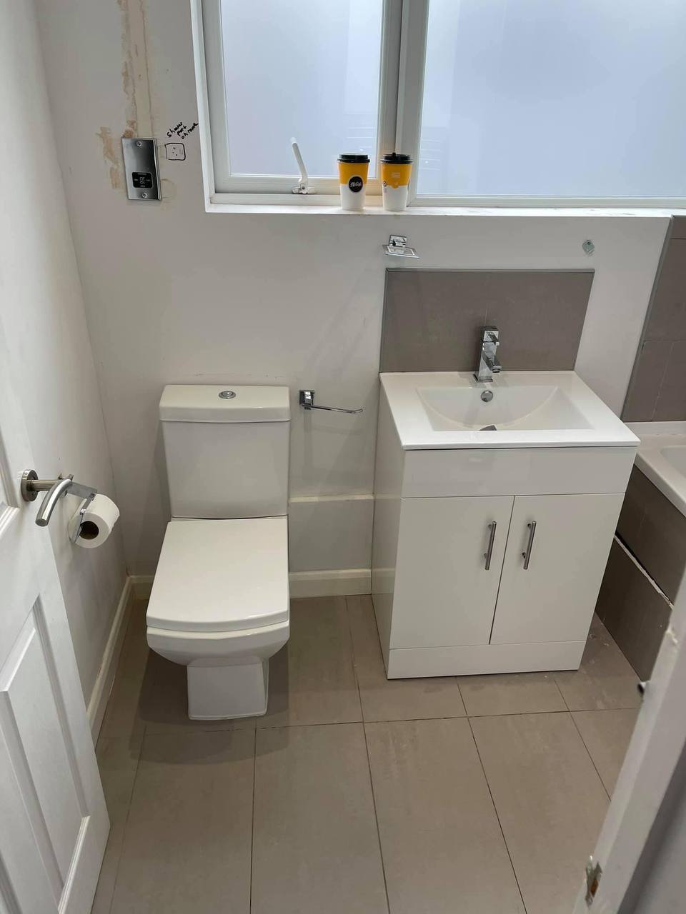 Newly installed close-coupled toilet next to a vanity unit in a South West London bathroom