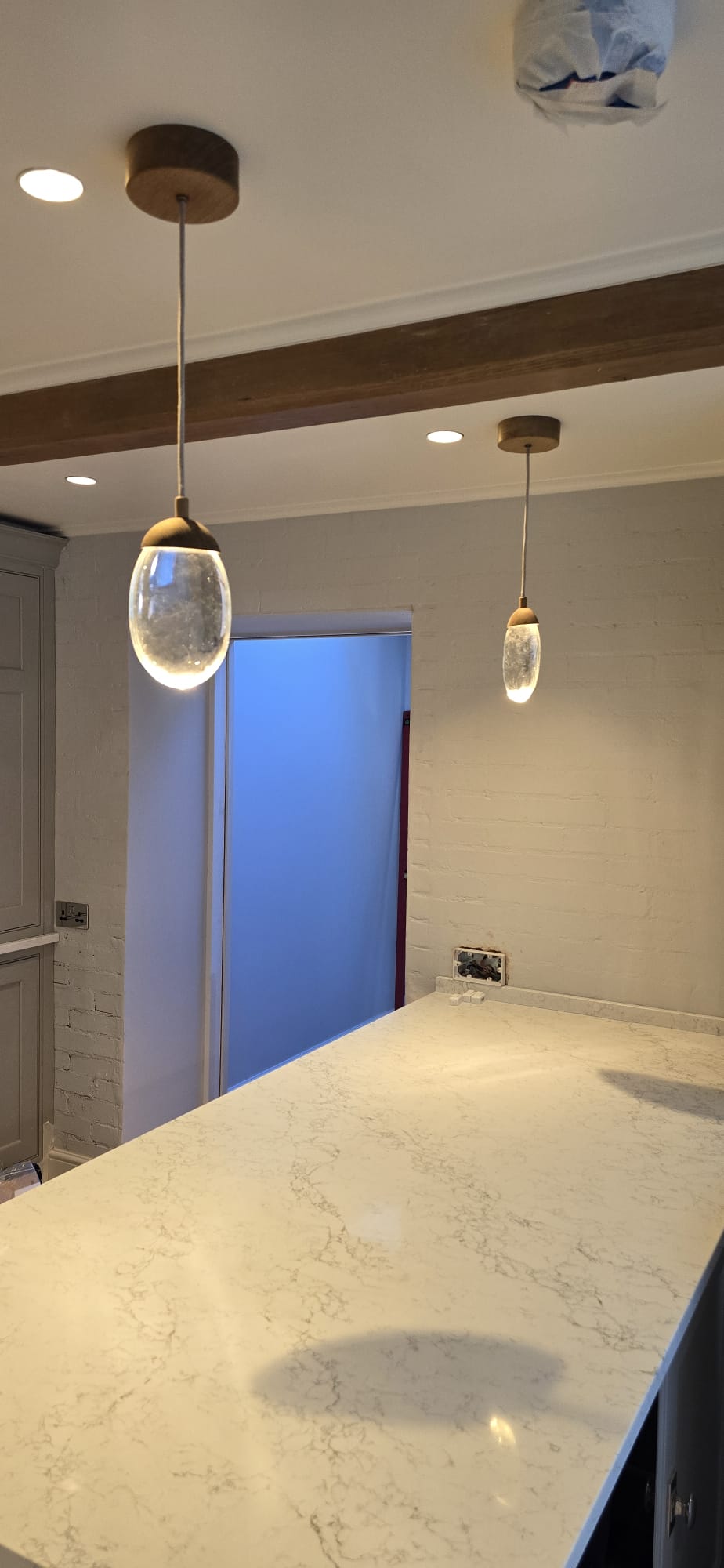 Pendant light installation over a kitchen island by Maxfix in Richmond