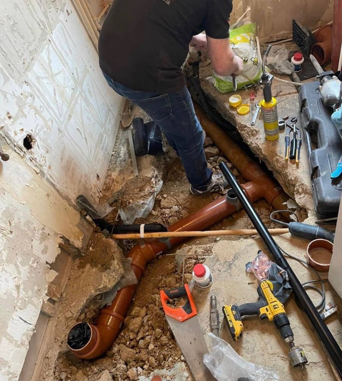 Emergency plumber carrying out drainage and pipework repairs in South West London