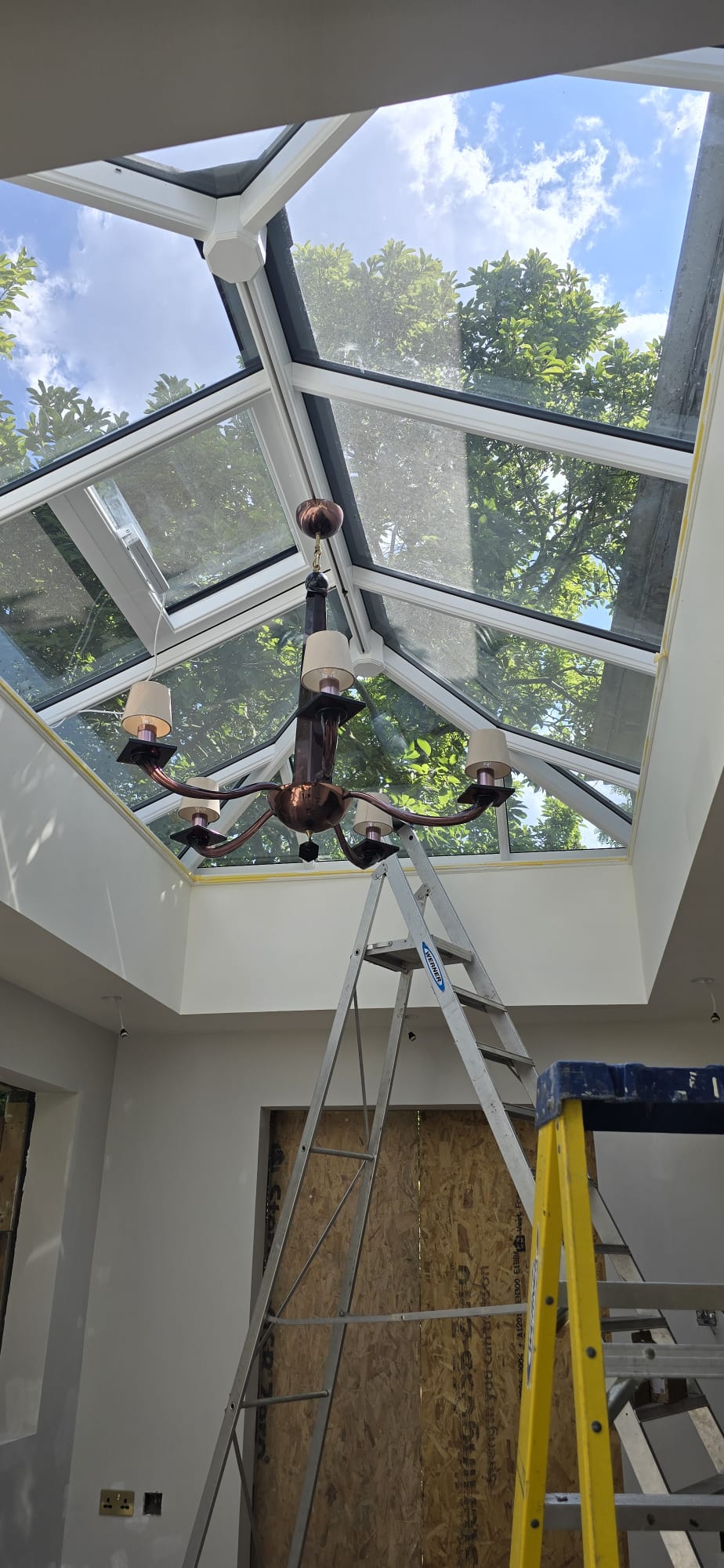 Chandelier installation beneath a roof lantern by Maxfix in Richmond