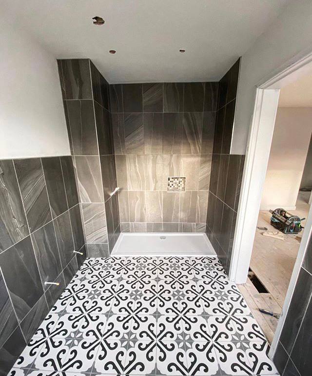 Grey marble-effect wall tiling with patterned monochrome floor tiles in South West London