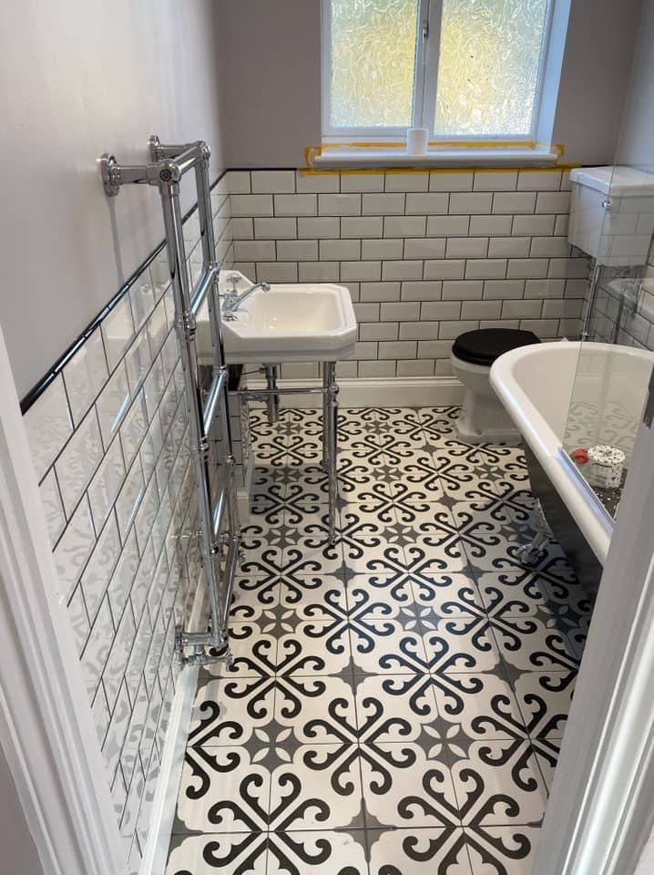 Refurbished bathroom with patterned encaustic floor tiles, metro wall tiles and traditional basin in South West London